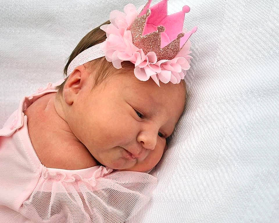 Holly is registered to the contest to win money with this photo: baby, baby_toddler_clothing, cheek, child, comfort, costume_hat, ear, eyebrow, eyelash, fashion_accessory, hair_accessory, head, headband, headgear, headpiece, headwear, magenta, pattern, person, petal