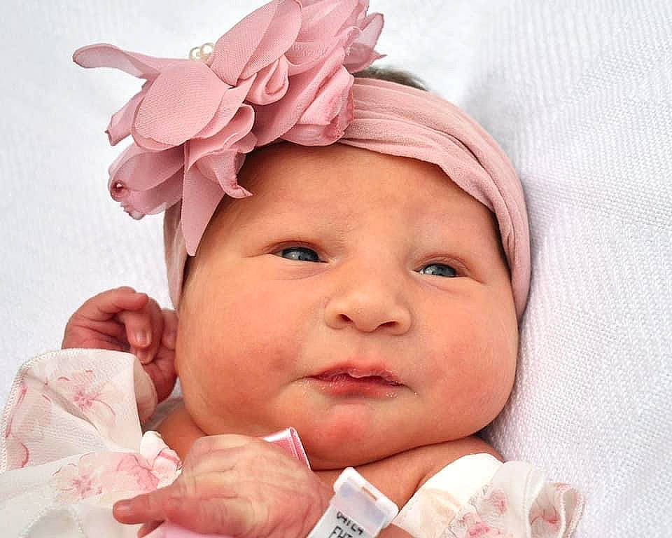 Holly is registered to the contest to win money with this photo: baby, chin, comfort, ear, eyelash, fashion_accessory, finger, gesture, happy, head, headband, headgear, headpiece, headwear, lip, person, pink, skin, smile, sweetness