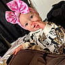 baby, child, pink_bow, headband, mickey_mouse, minnie_mouse, sweater, leopard_print, finger_in_mouth, car_seat, indoor, curtain, bed, blanket, cute, portrait, young_child, person, clothing, infant