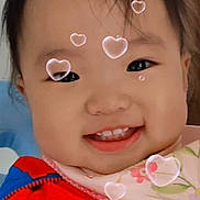 Allison joined the competition — help win amazing prizes! child, toddler, smiling, face, baby, heart_bubble, red_jacket, bib, cute, indoors, portrait, happy, young_child, headshot, black_hair, cheeks, expression, playful, closeup, warm_clothing