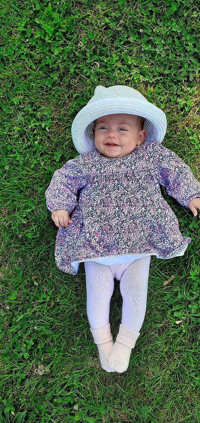 Shelby participe au concours pour gagner de l'argent avec cette photo : baby, baby_toddler_clothing, child, eye, fashion_accessory, grass, hand, happy, headwear, joy, leaf, leggings, outerwear, pattern, people_in_nature, person, plant, sleeve, smile, sun_hat