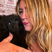 Winnie a rejoint le concours — aidez-le/la à gagner de superbes lots ! woman, dog, black_dog, pet, portrait, close_up, blonde_hair, long_hair, hand, ring, indoor, wall, brick_wall, framed_picture, cute, expression, face, animal, furry, holding