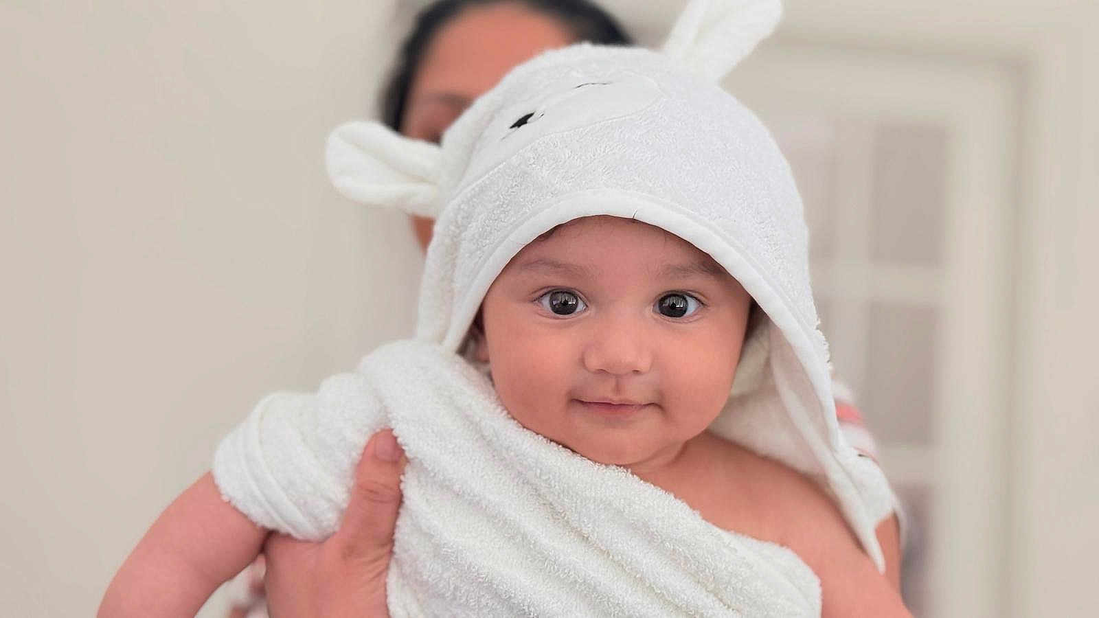Krishiv is registered to the contest to win money with this photo: baby, child, towel, white, bunny_ears, cute, face, portrait, person, skin, hand, indoor, soft, closeup, expression, holding, infant, newborn, smiling, cozy