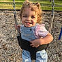 toddler, child, swing, playground, smile, denim_overalls, pink_shirt, chains, wood_chips, outdoor, daylight, happy, curly_hair, holding, park, fun, person, young_child, clothing, nature