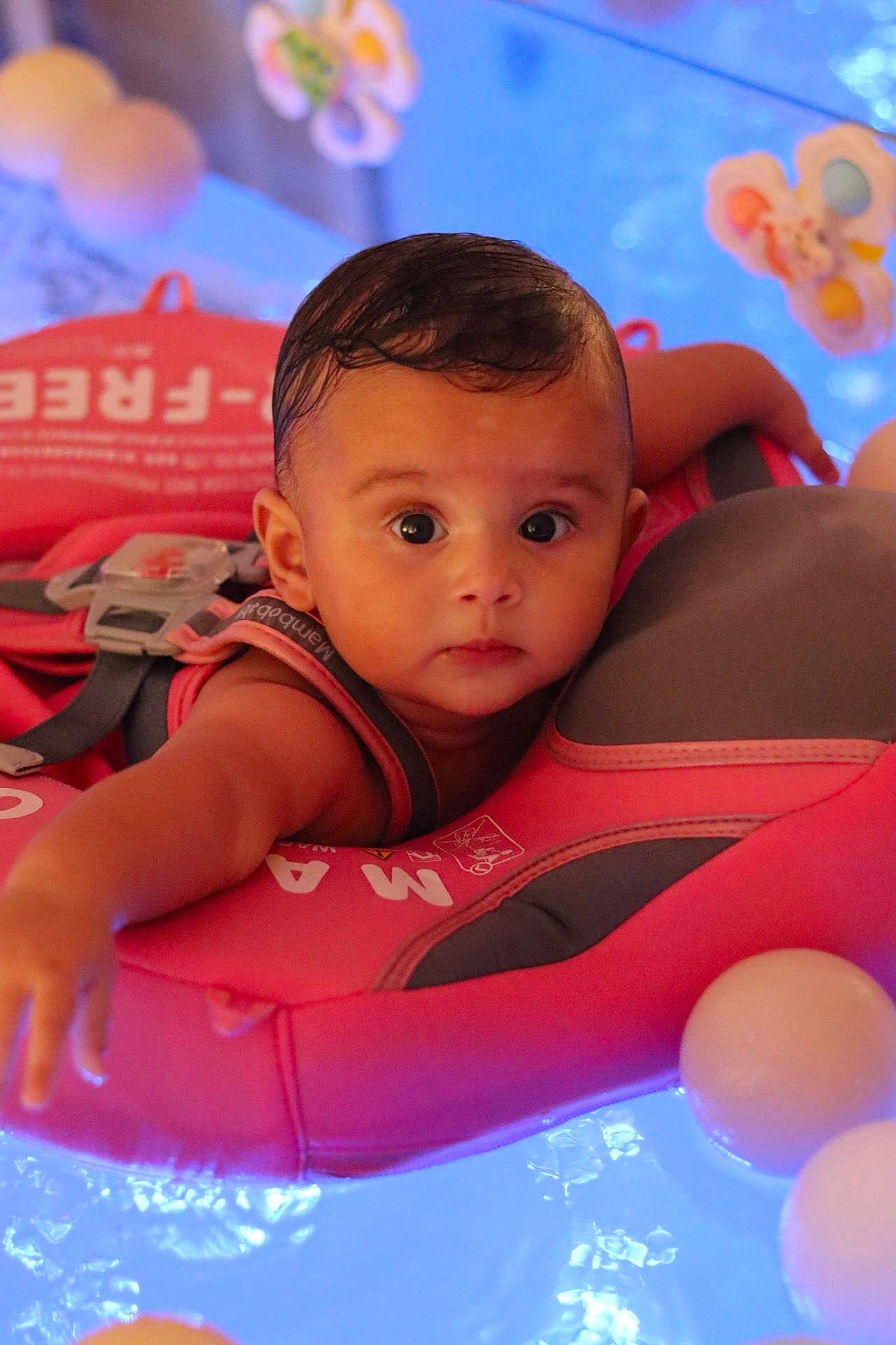 Layna a rejoint le concours — aidez-le/la à gagner de superbes lots ! baby, infant, life_vest, water, floating, pool, blue_light, pink, child, face, eyes, expression, ball, safety, swimming, head, arm, cute, portrait, indoor
