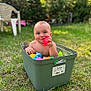 baby, child, toy, storage_bin, grass, outdoor, nature, play, colorful, water, summer, greenery, plastic, happy, cute, smile, sunlight, fun, garden, relax
