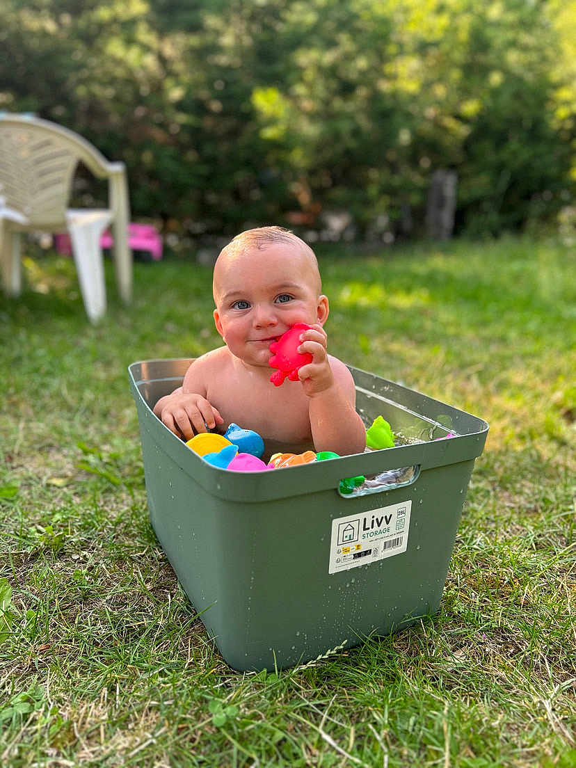Layton participe au concours pour gagner de l'argent avec cette photo : baby, child, toy, storage_bin, grass, outdoor, nature, play, colorful, water, summer, greenery, plastic, happy, cute, smile, sunlight, fun, garden, relax