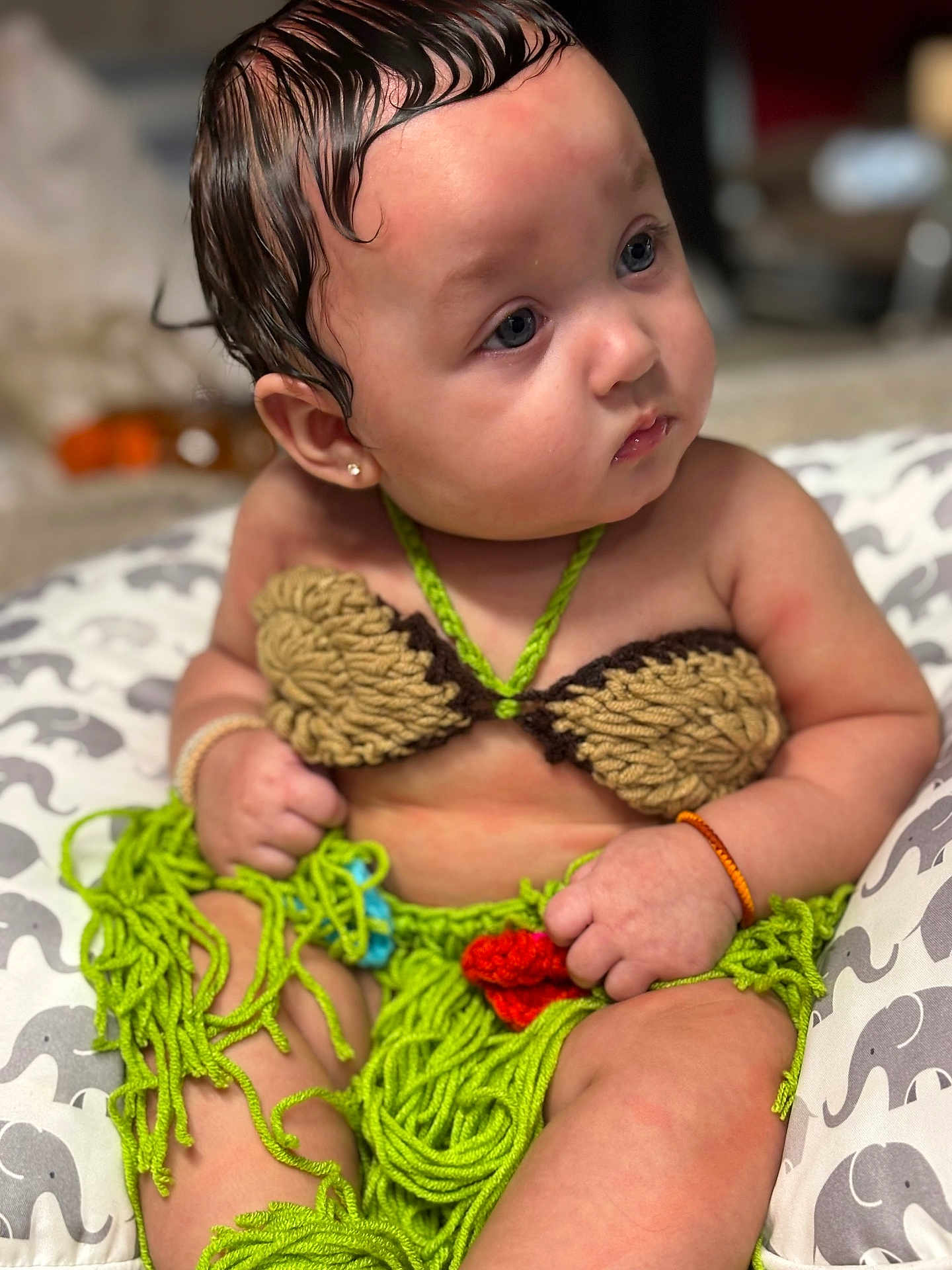 Keomi joined the competition — help win amazing prizes! baby, child, crochet_outfit, handmade, colorful_clothing, sitting, cushion, patterned, curious_look, wet_hair, bracelet, cute, indoors, portrait, closeup, young_child, soft_lighting, skin, face, expression