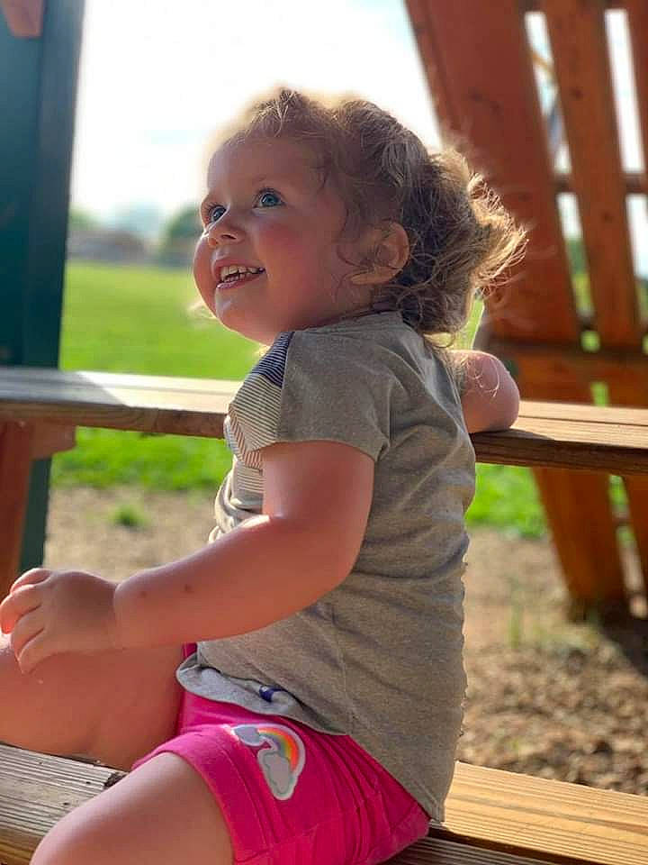Blakelynn is registered to the contest to win money with this photo: baby, cheek, child, eye, fun, grass, leg, leisure, outdoor_play_equipment, person, pink, play, playground, public_space, sitting, skin, smile, summer, swing, toddler