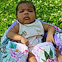 baby, infant, child, outdoor, grass, flower, greenery, baby_seat, floral_pattern, blanket, sunlight, nature, person, portrait, cute, skin, clothing, summer, relaxing, sitting