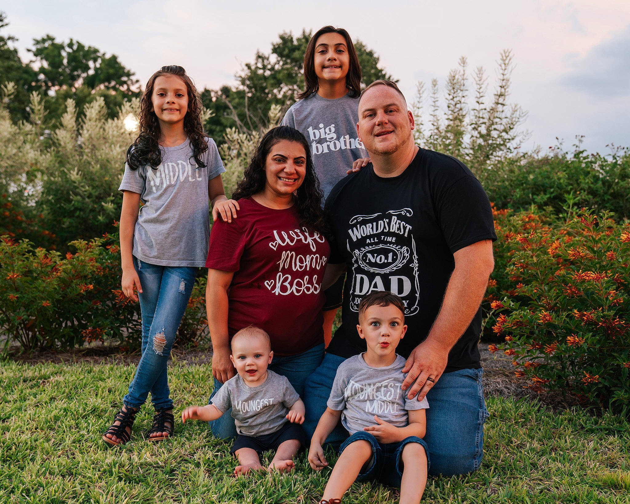 Bennett is registered to the contest to win money with this photo: clothing, face, family_taking_photos_together, flower, fun, grass, happy, head, jeans, joy, leisure, people_in_nature, person, plant, red, shorts, sky, smile, standing, t_shirt