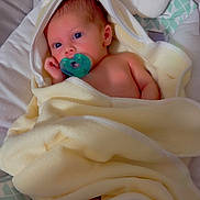 Kayden is registered to the contest to win money with this photo: baby, blanket, pacifier, infant, soft, cushion, face, skin, eyes, wrapped, yellow, newborn, cute, indoors, comfort, child, peaceful, portrait, head, resting