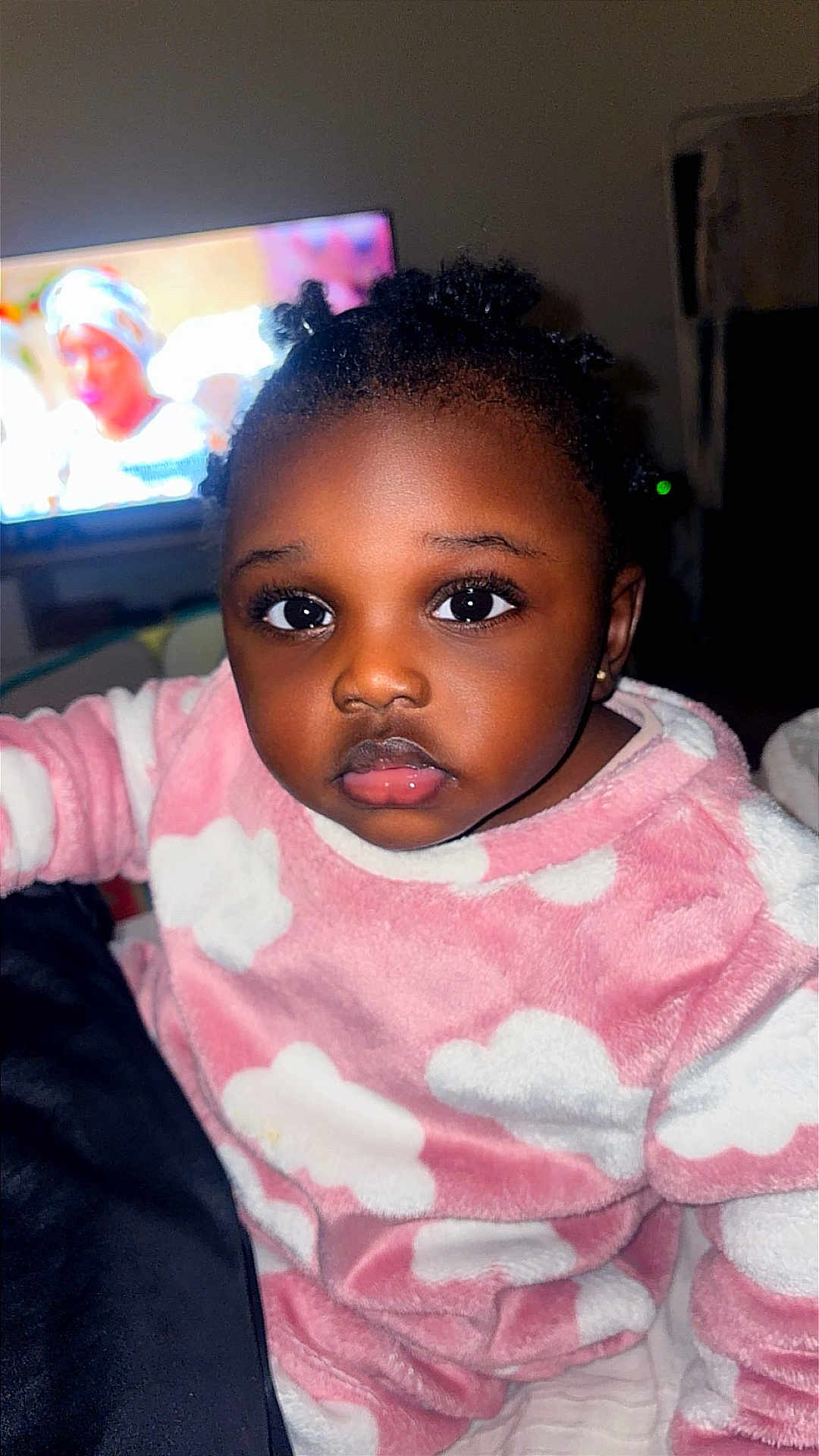 Amynatha participe au concours pour gagner de l'argent avec cette photo : child, toddler, baby, onesie, pajamas, pink_clothing, cloud_pattern, face, eyes, big_eyes, eyelashes, hair, earring, portrait, indoor, television, background, blanket, candid, soft_fabric