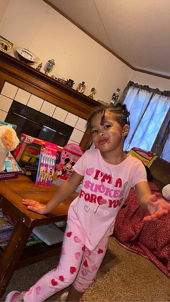 Maryjane is registered to the contest to win money with this photo: chair, child, curtain, event, fashion_design, flooring, fun, happy, human_leg, leg, leisure, magenta, person, play, room, sitting, t_shirt, table, thigh, toddler