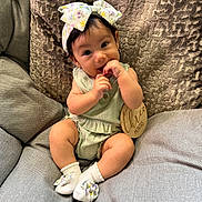 Sosa is registered to the contest to win money with this photo: baby, infant, child, cute, sitting, couch, headband, bow, socks, clothing, wooden_sign, three_months, fingers, portrait, indoor, soft_lighting, happy, smiling, curious, comfortable