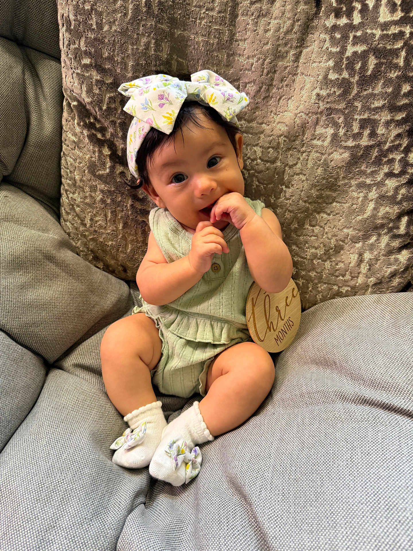 Sosa is registered to the contest to win money with this photo: baby, infant, child, cute, sitting, couch, headband, bow, socks, clothing, wooden_sign, three_months, fingers, portrait, indoor, soft_lighting, happy, smiling, curious, comfortable