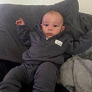 Drevaughn joined the competition — help win amazing prizes! baby, infant, child, grey_clothing, blanket, cushion, sofa, indoor, portrait, face, looking_at_camera, cozy, comfortable, sitting, young_child, cute, soft_texture, home, casual, relaxed