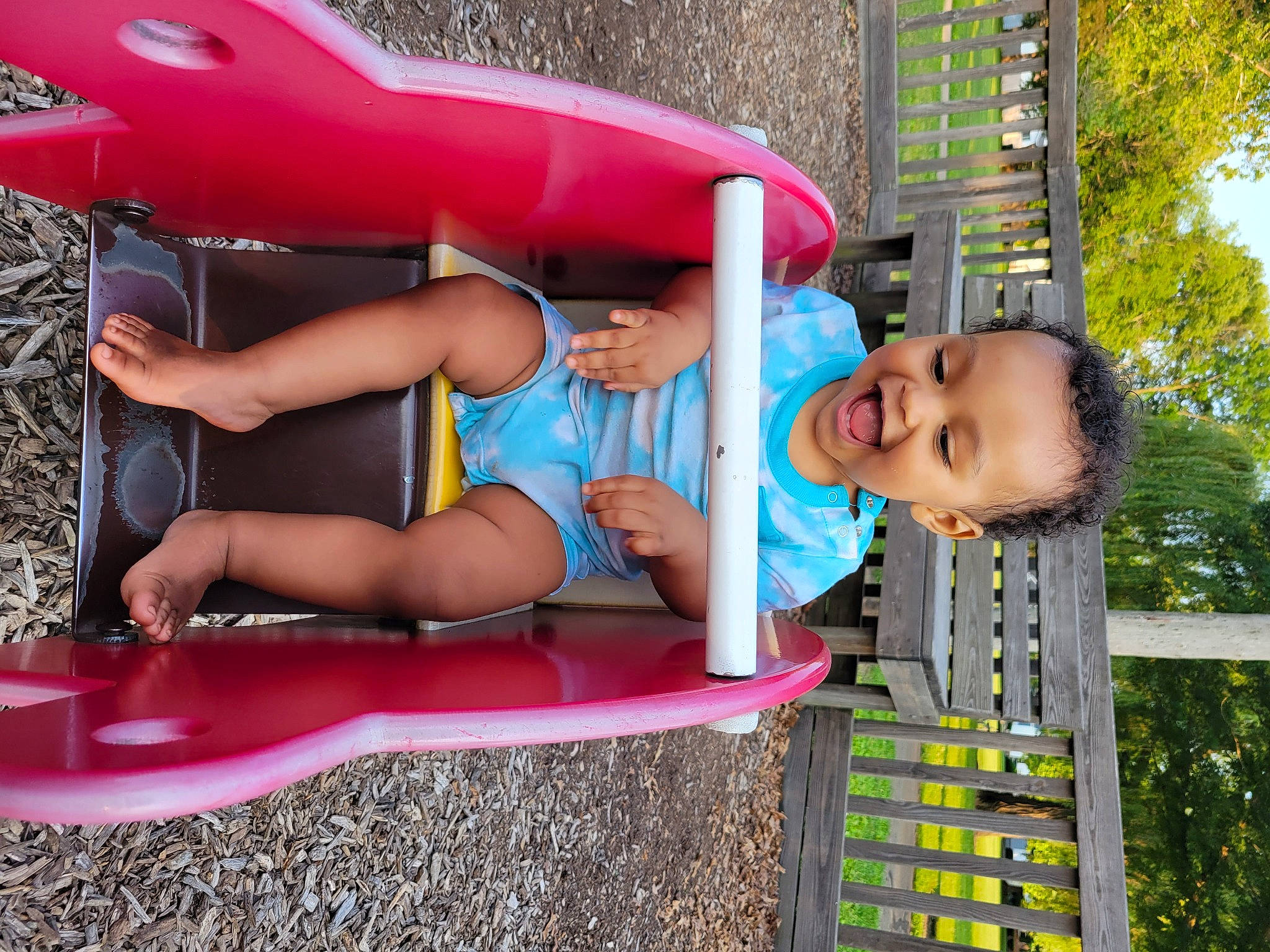 Jalen is registered to the contest to win money with this photo: automotive_exterior, boats_and_boating_equipment_and_supplies, bumper, fun, grass, human_body, leisure, motor_vehicle, person, pink, public_space, red, shorts, smile, summer, thigh, toddler, tree, vehicle, vehicle_door