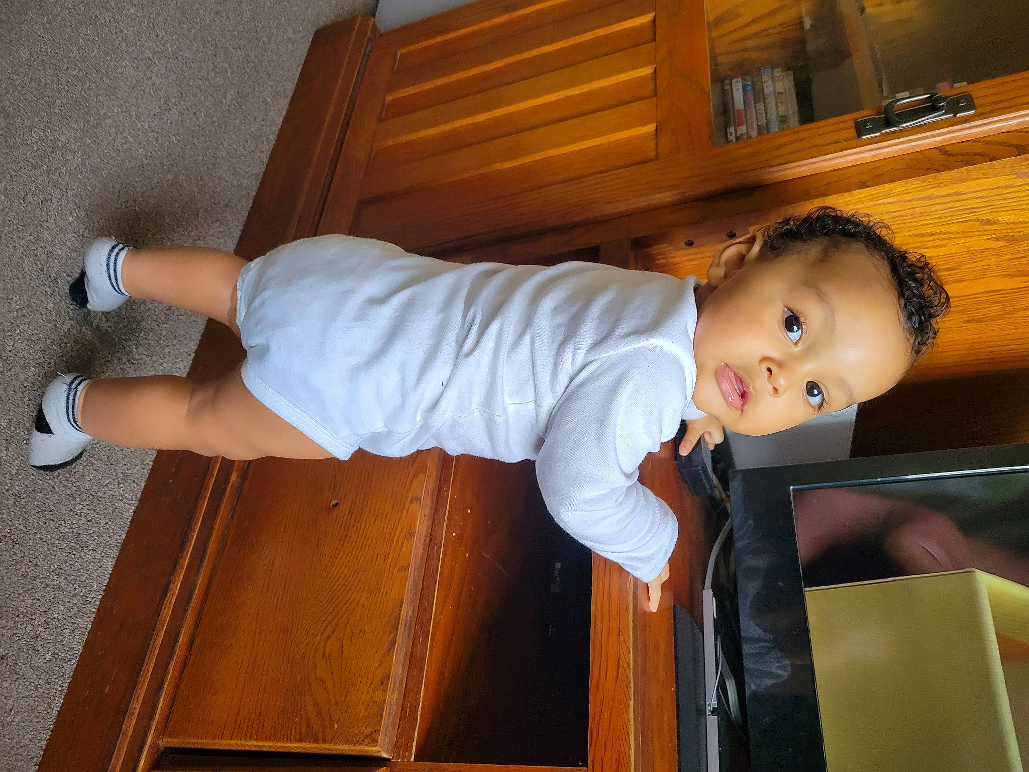 Jalen is registered to the contest to win money with this photo: baby, baby_toddler_clothing, child, comfort, elbow, flooring, fun, hardwood, human_leg, knee, person, room, sitting, sleeve, smile, t_shirt, thumb, toddler, varnish, wood