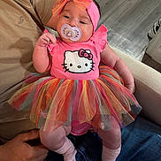 Andrea is registered to the contest to win money with this photo: baby, infant, pacifier, headband, bow, tutu, dress, hello_kitty, pink, socks, sitting, arm, legs, sofa, floor, shoes, denim, hand, portrait, cute