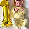 Alicia a rejoint le concours — aidez-le/la à gagner de superbes lots ! baby, baby_face, balloon, celebration, child, cute, headband, indoors, infant, lying_down, milestone, newborn, number_one, one_year, portrait, small_hands, socks, soft_texture, white_blanket, yellow_clothing