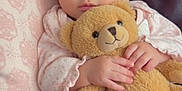 Elliana is registered to the contest to win money with this photo: baby, teddy_bear, pink_bow, pillow, couch, infant, soft_toy, clothing, headband, cute, child, portrait, indoor, cozy, hands, face, expression, knitwear, seated, young_child