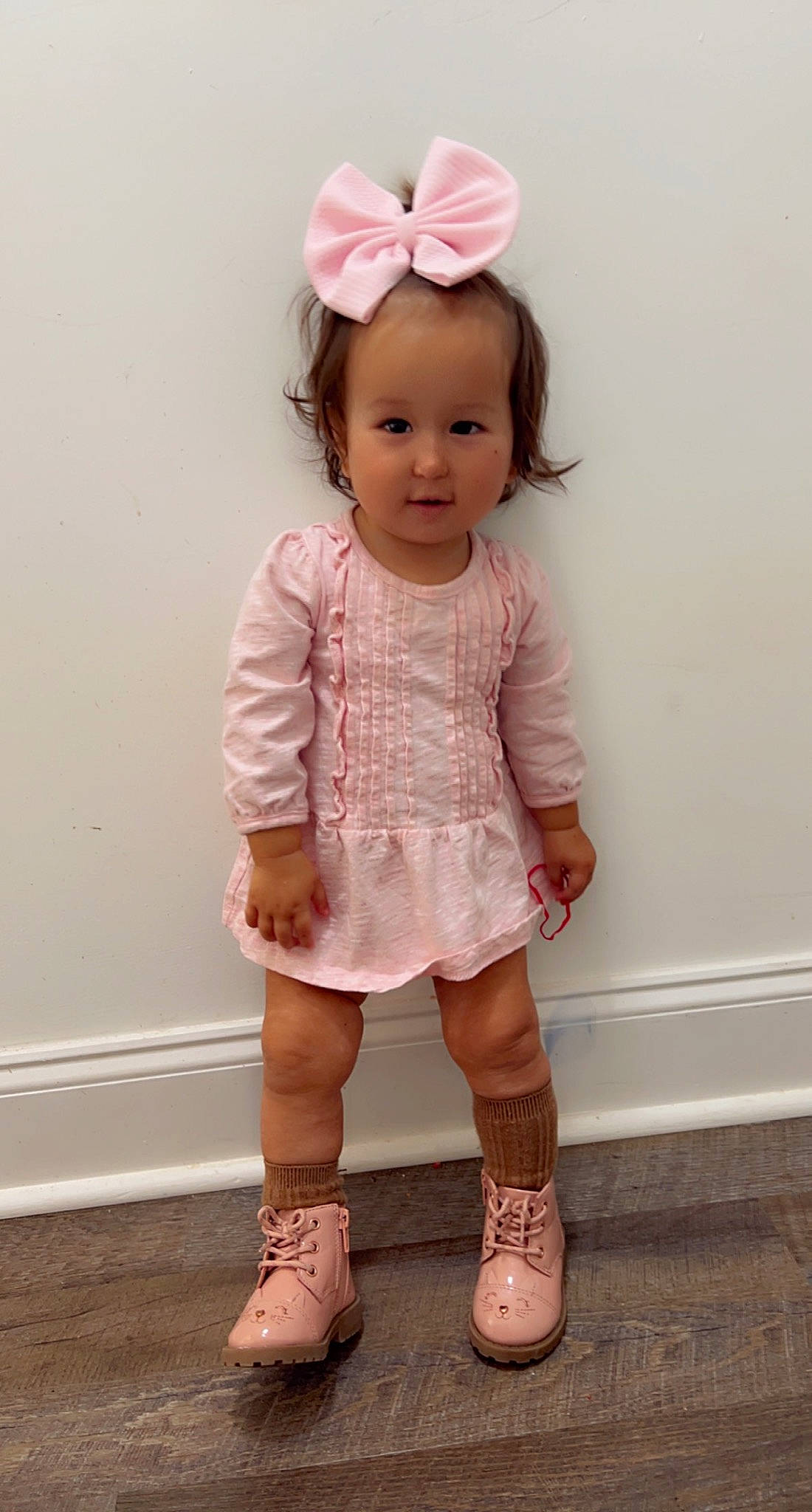 Luna is registered to the contest to win money with this photo: baby_toddler_clothing, cheek, chin, clothing, dress, dress_shirt, eyelash, face, hair, happy, head, leg, lip, neck, person, pink, skin, sleeve, sock, standing