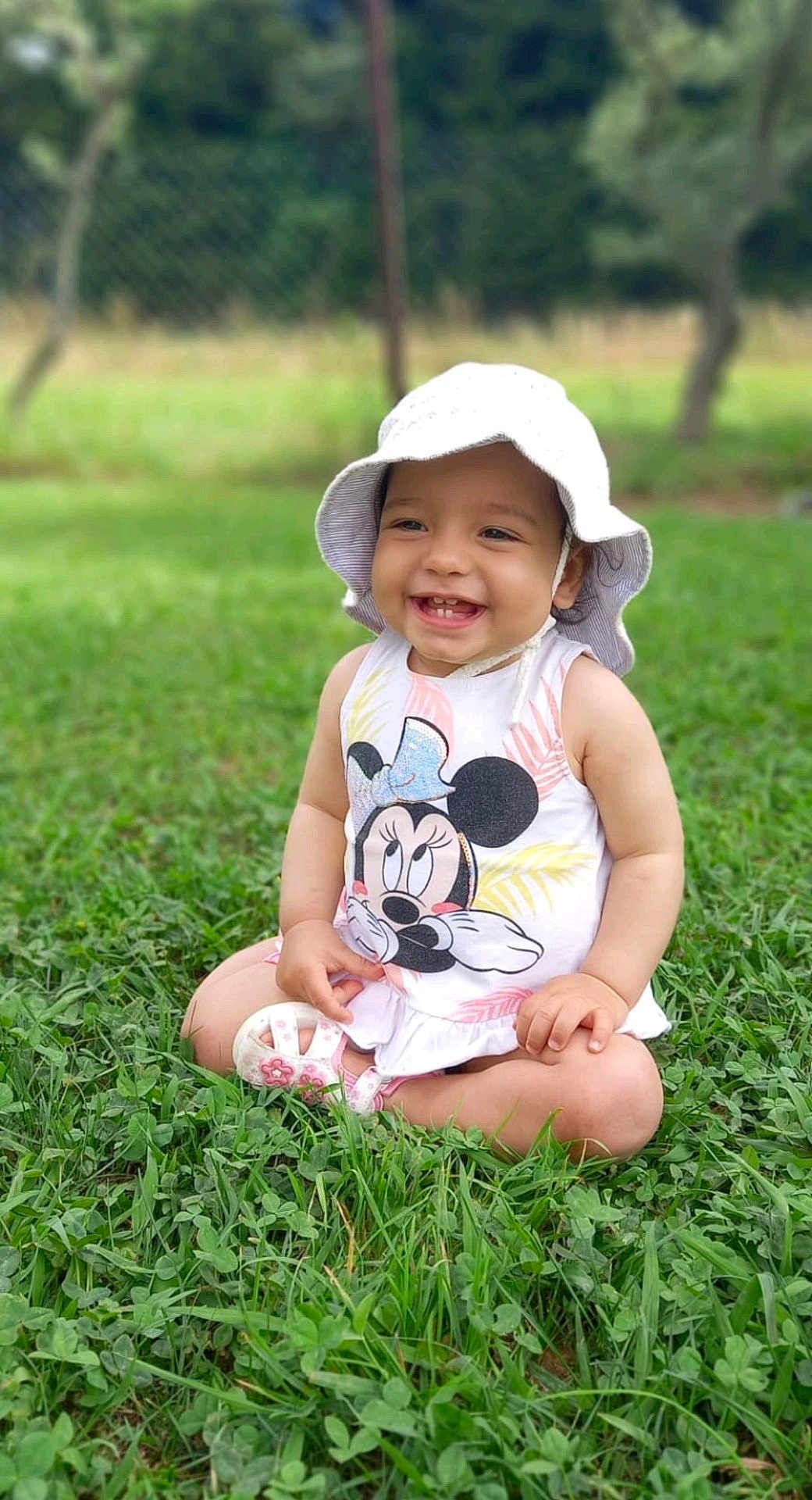 Mélia participe au concours pour gagner de l'argent avec cette photo : baby, cap, clothing, dress, face, grass, hat, head, lawn, nature, outdoors, park, person, photography, plant, portrait, sitting, summer, sunhat, vegetation