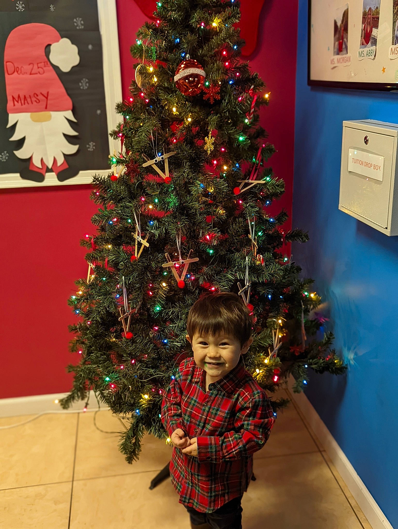 Jae joined the competition — help win amazing prizes! christmas, christmas_decoration, christmas_eve, christmas_ornament, christmas_tree, event, evergreen, holiday, holiday_ornament, joy, larch, ornament, person, picture_frame, plant, red, smile, standing, toddler, tree
