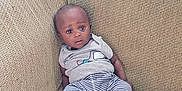 Josiah is registered to the contest to win money with this photo: applesauce, baby, casual_clothing, child, comfortable, couch, curtains, expression, food_container, furniture, grey_shirt, home, indoors, portrait, seated, sofa, striped_pants, textured_fabric, wide_eyes, young_child