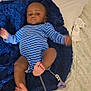 baby, infant, blue_onesie, striped_clothing, blanket, bed, pillow, medical_tubing, child, indoor, person, legs, arms, feet, head, face, curious, lying_down, soft_texture, home