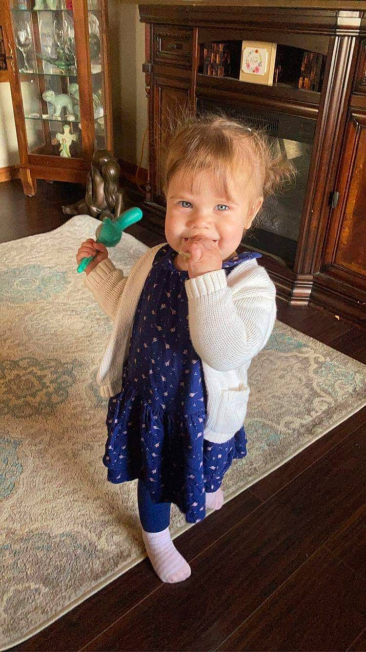 Armani is registered to the contest to win money with this photo: baby, baby_toddler_clothing, cabinetry, electric_blue, floor, flooring, foot, hardwood, human_body, human_leg, joy, linens, pattern, person, picture_frame, room, sitting, sleeve, smile, sock