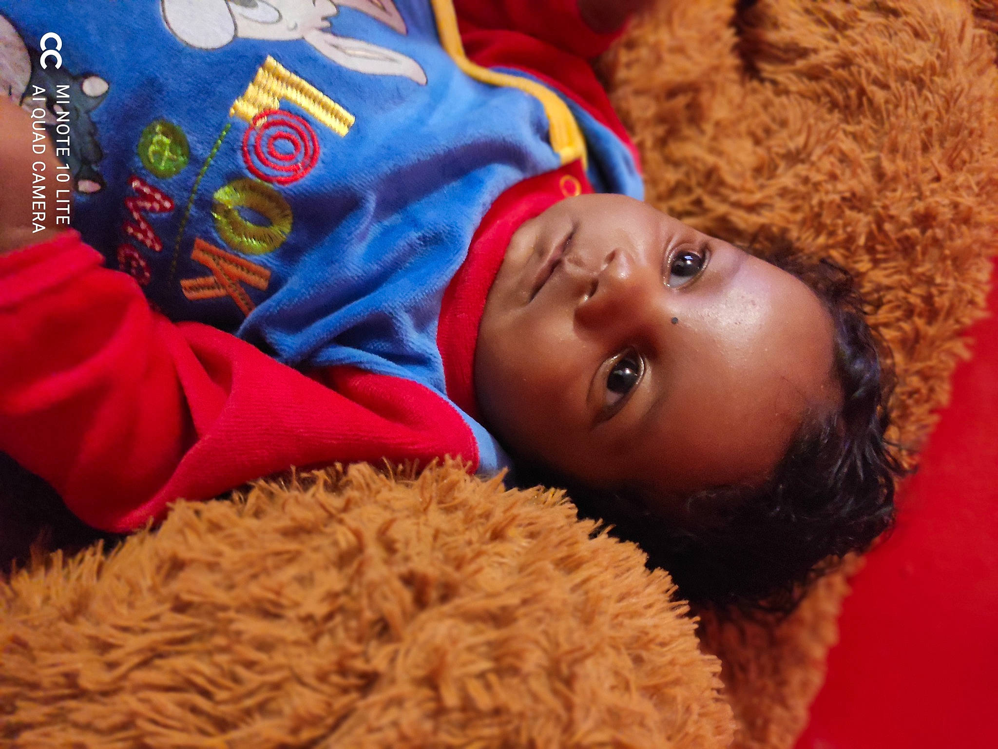 Illan participe au concours pour gagner de l'argent avec cette photo : baby, baby_toddler_clothing, cheek, child, comfort, face, flooring, fun, fur, happy, headgear, linens, nose, people, person, room, sand, skin, textile, toddler