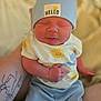 Robert is registered to the contest to win money with this photo: arm, baby, blue_hat, clothing, cuddly, cute, hand, hat, hello_text, human, indoors, infant, newborn, person, portrait, skin, sleeping, smiling_sun, soft_light, tattoo