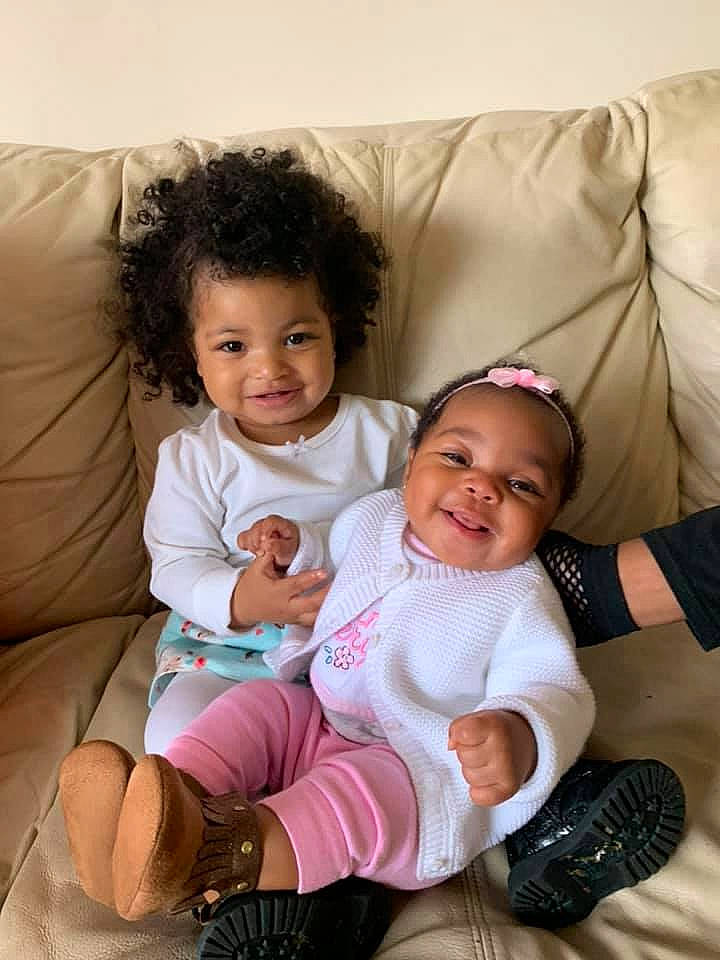 Melyia is registered to the contest to win money with this photo: baby, baby_toddler_clothing, cheek, child, comfort, couch, eye, facial_expression, finger, glove, hand, happy, human, joy, lap, mouth, nose, person, shoe, smile