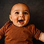 baby, child, smiling, happy, face, portrait, infant, cute, clothing, brown_shirt, arms, closeup, studio, expression, joy, young, skin, head, eyes, background
