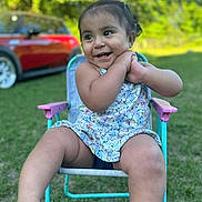 Massiel is registered to the contest to win money with this photo: toddler, child, smiling, outdoor, grass, chair, summer_clothing, happy, person, portrait, daylight, nature, car, greenery, cute, sitting, playful, sunlight, baby, casual