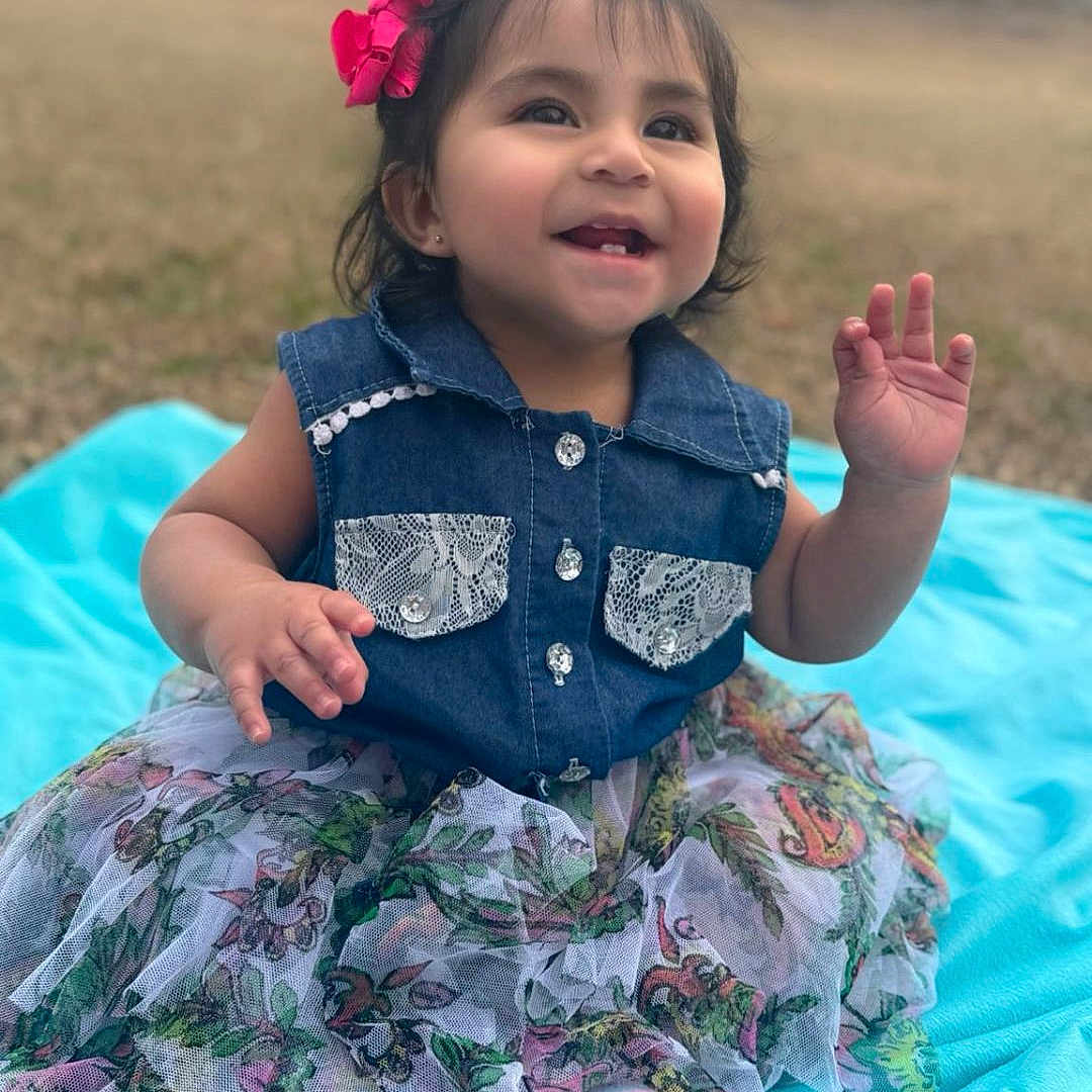 Massiel is registered to the contest to win money with this photo: toddler, child, smiling, outdoor, grass, denim, dress, bow, happy, sitting, blanket, cute, portrait, young_child, fashion, playful, person, fun, nature, baby