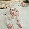 Bryce is registered to the contest to win money with this photo: baby, infant, child, smiling, happy, crawling, portrait, face, blue_eyes, white_hat, bib, long_sleeves, bed, bedding, bedroom, indoor, toy, blue_toy, hands, playful