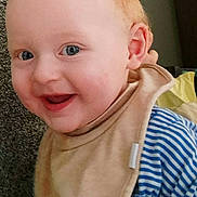 Bryce joined the competition — help win amazing prizes! baby, child, infant, smiling, happy, portrait, face, eyes, mouth, blond_hair, striped_clothing, bib, blue, white, indoor, carpet, close_up, sitting, cheerful, photography
