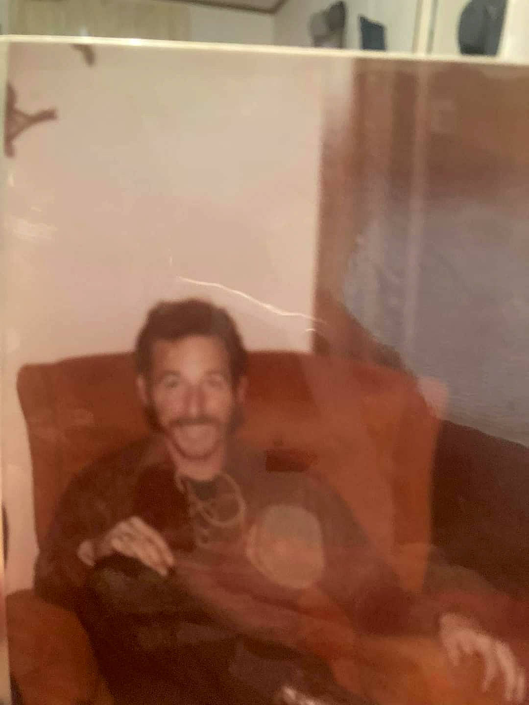 Jericho is registered to the contest to win money with this photo: beard, comfort, facial_hair, flesh, fun, hardwood, joy, person, room, sitting, t_shirt, thumb, tints_and_shades, wood