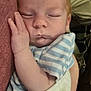 baby, sleeping, infant, hand, striped_clothing, blanket, arm, person, closeup, face, peaceful, resting, comfort, cuddle, young_child, indoor, parent, holding, skin, casual_clothing