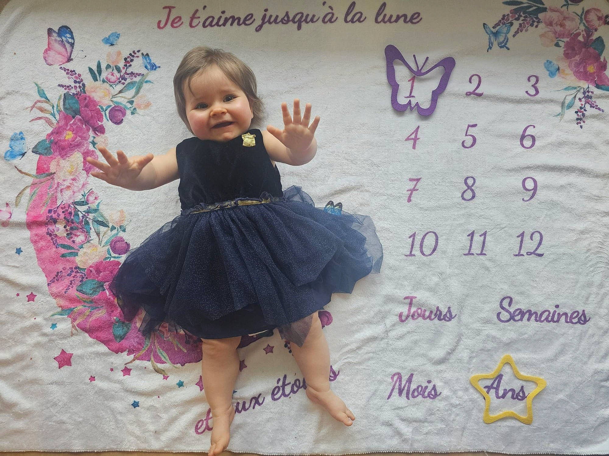 Annie a rejoint le concours — aidez-le/la à gagner de superbes lots ! baby, baby_toddler_clothing, child, day_dress, dress, embellishment, event, finger, fun, happy, joy, linens, magenta, pattern, person, pink, purple, sleeve, smile, toddler