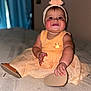 Kevrianys Sophia joined the competition — help win amazing prizes! baby, child, smile, dress, headband, bed, indoor, cute, person, happy, sitting, footwear, hand, face, skin, apparel, infant, portrait, young_child, cheeks