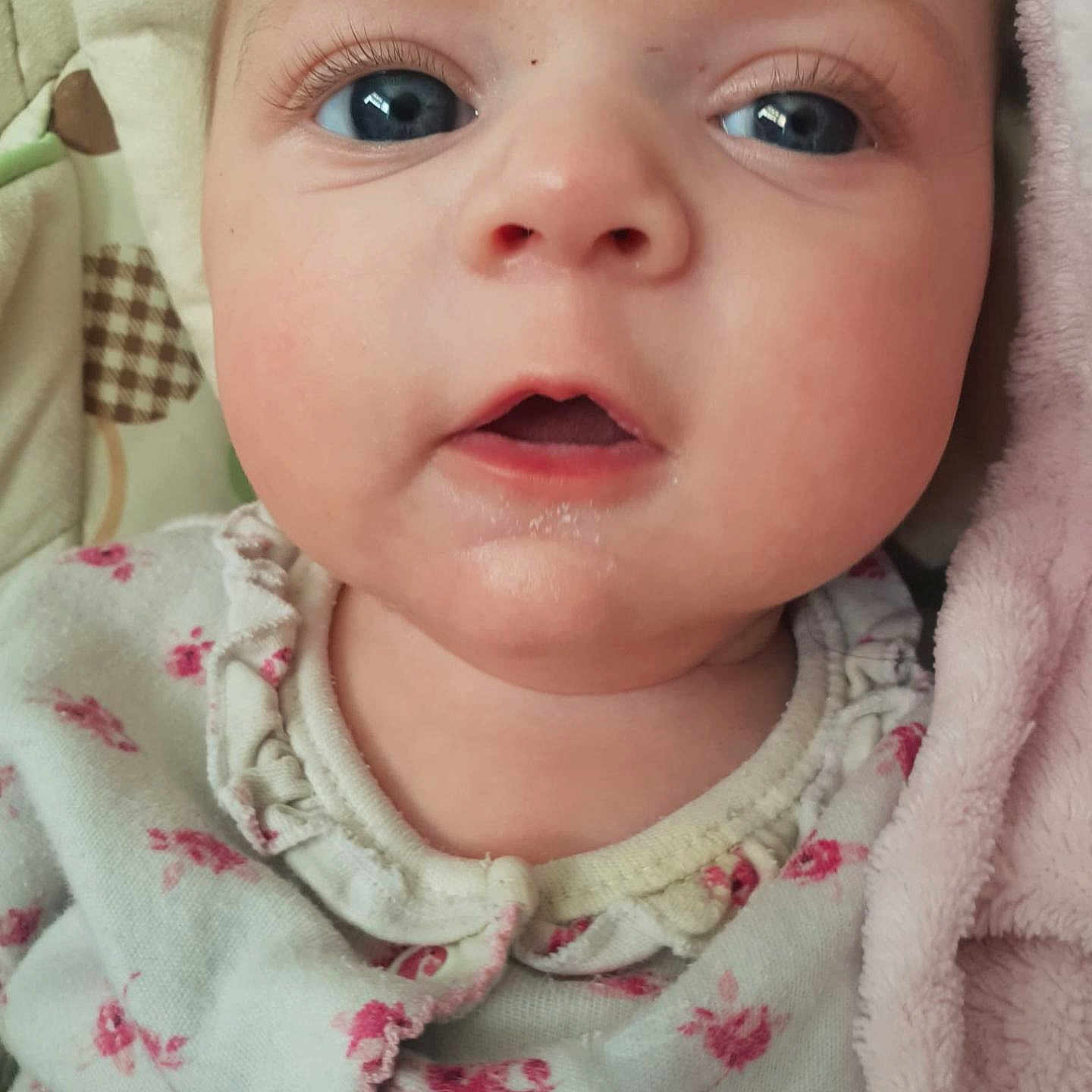 Halley-Ann joined the competition — help win amazing prizes! baby, blue_eyes, child, close_up, cute, expression, eyelashes, face, floral_clothing, head, indoors, infant, mouth_open, newborn, pink_blanket, portrait, skin, sleepwear, soft_texture, young