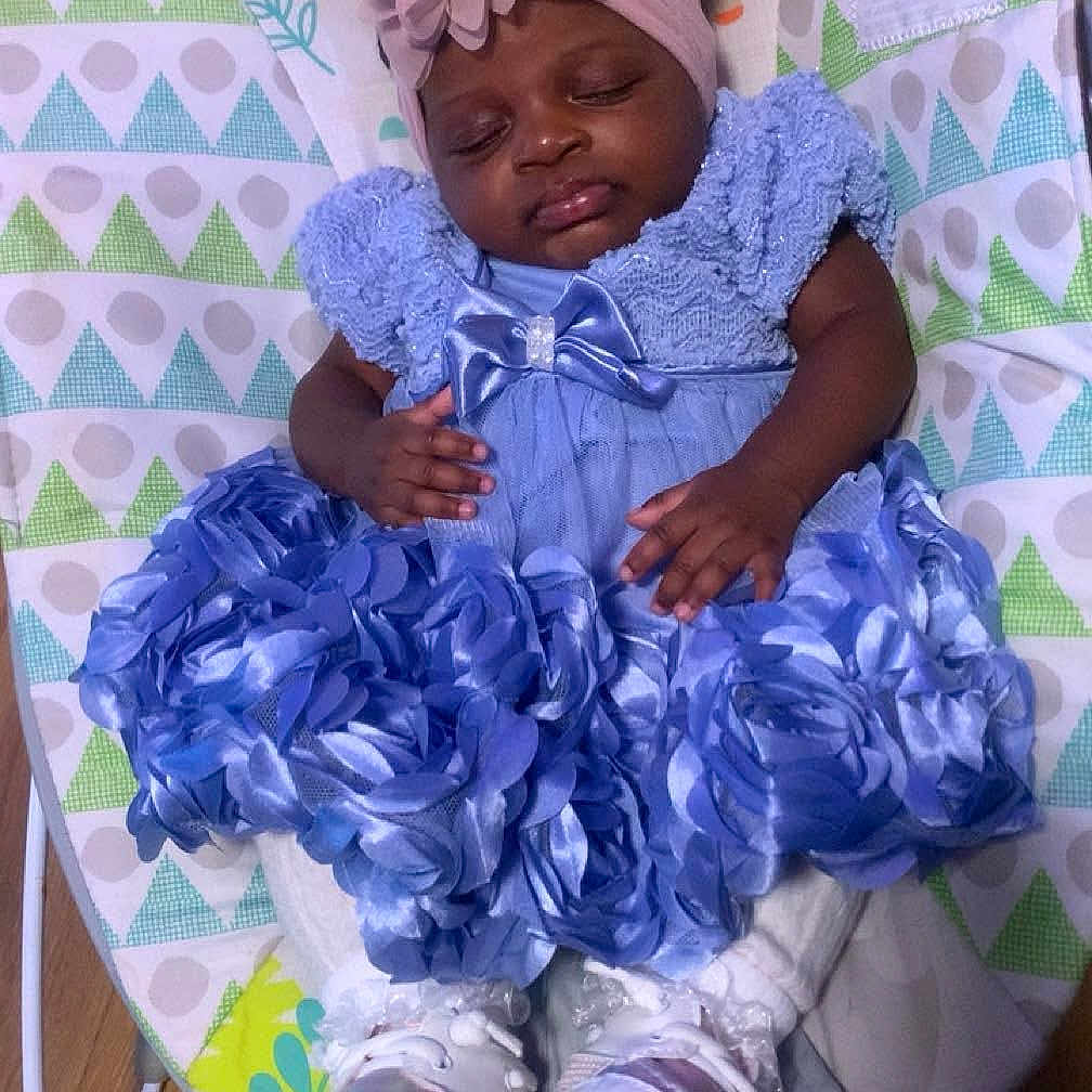 Xiomara joined the competition — help win amazing prizes! accessory, baby, baby_bouncer, baby_fashion, blue_dress, child, clothing, cute, floor, headband, indoor, infant, lion_illustration, peaceful, portrait, resting, shoes, sleeping, toddler, wooden_floor