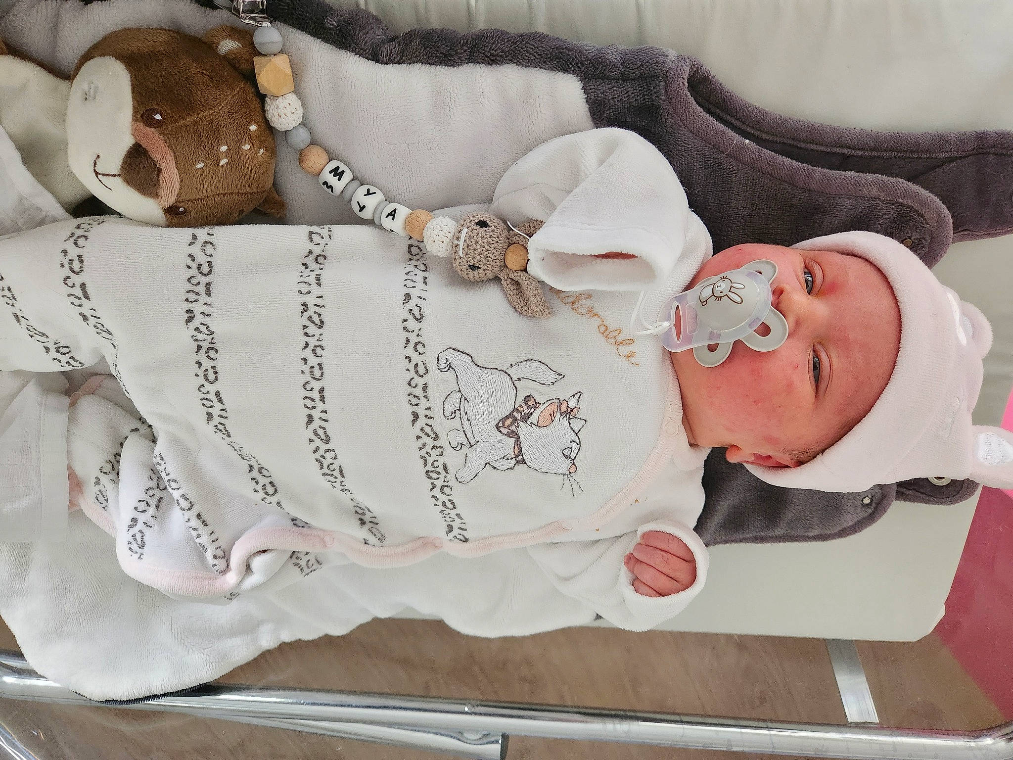 Mya a rejoint le concours — aidez-le/la à gagner de superbes lots ! baby, baby_products, baby_toddler_clothing, body_jewelry, child, collar, comfort, embellishment, fashion_accessory, hand, headgear, human_body, jewellery, necklace, pattern, person, pink, sleeve, waist, white