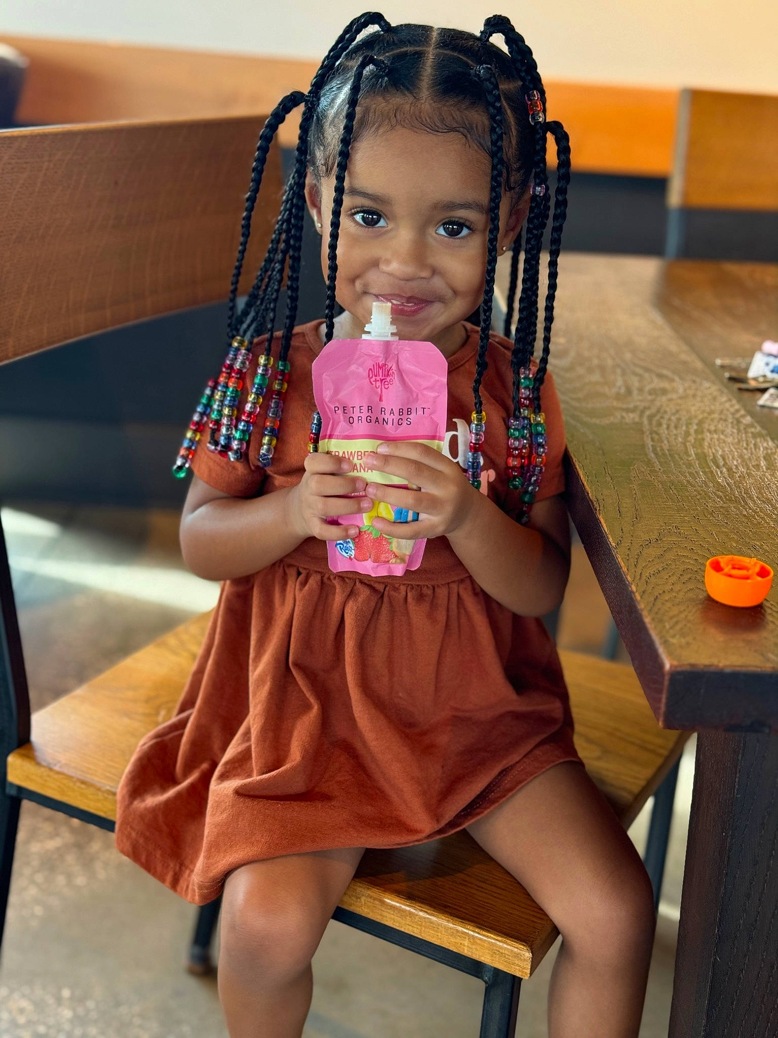 Reign is registered to the contest to win money with this photo: baby_toddler_clothing, chair, child, dress, event, finger, foot, fun, happy, human_body, human_leg, joy, leisure, person, room, sitting, skin, smile, snapshot, table