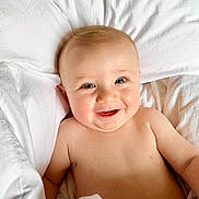 Magnus a rejoint le concours — aidez-le/la à gagner de superbes lots ! baby, infant, smiling, pillow, blanket, white_sheet, bed, cheeks, eyes, portrait, cute, happy, skin, bare_chest, lying_down, head, mouth, nursery, soft, adorable