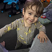 Liam joined the competition — help win amazing prizes! toddler, child, smile, pajamas, lion_king, indoor, carpet, toy, walker, person, face, hand, hair, living_room, basket, blanket, foot, clothing, expression, home